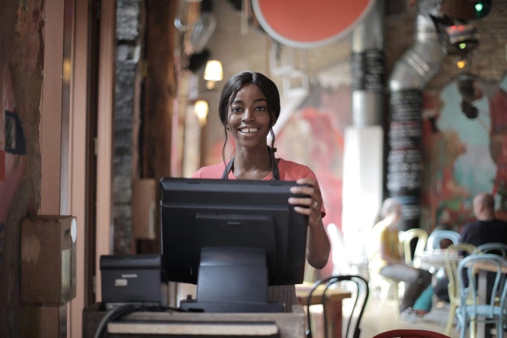 A woman of color at a restaurant hosting stand