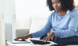 woman-using-calculator-and-laptop