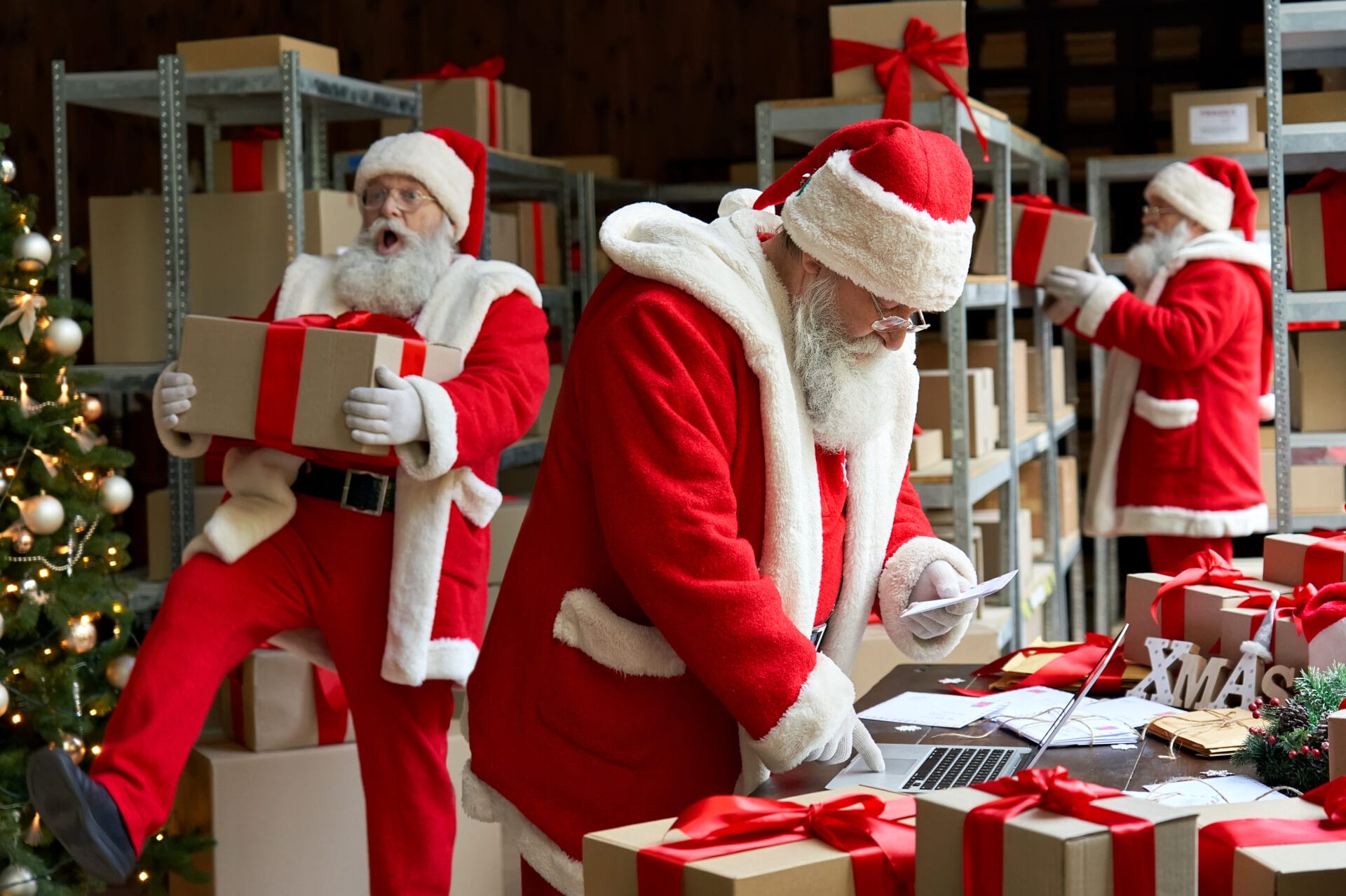 Warehouse scene with multiple Santas managing holiday gift boxes, depicting the hustle of seasonal work and the importance of on-demand workforce solutions for holiday business success.